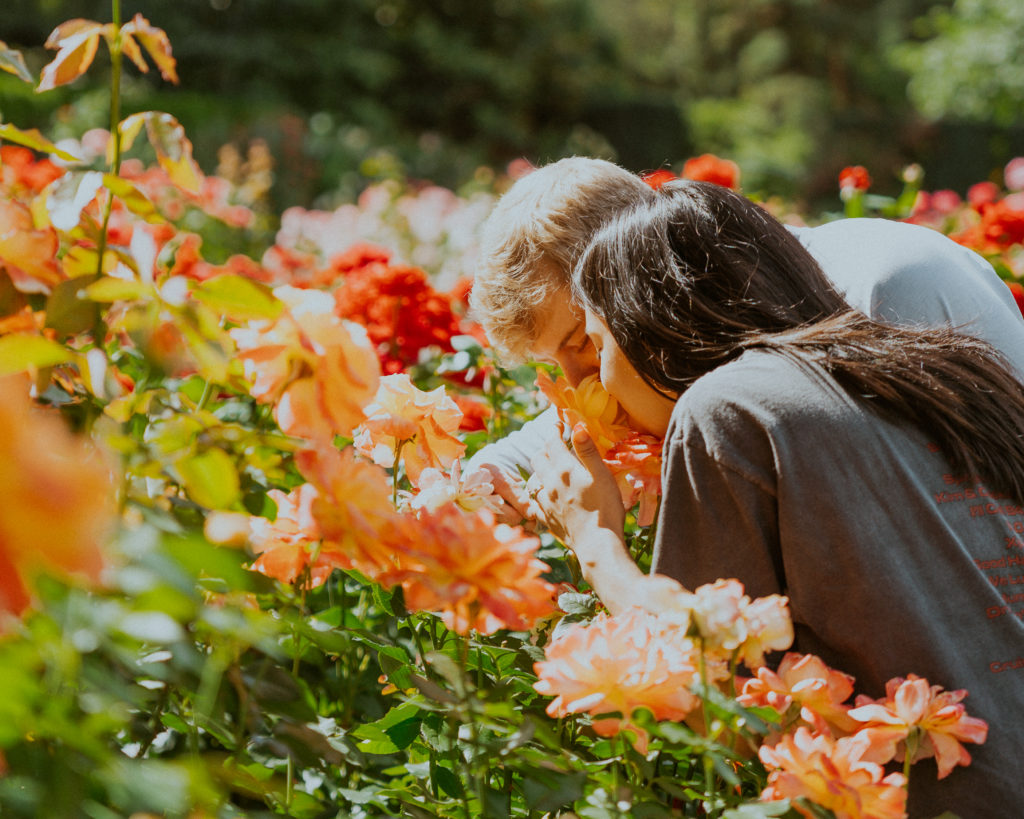 Couple surrounded by flowers and smelling them