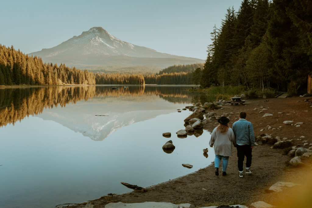 Couple walking along a lake with a mountain view in the background